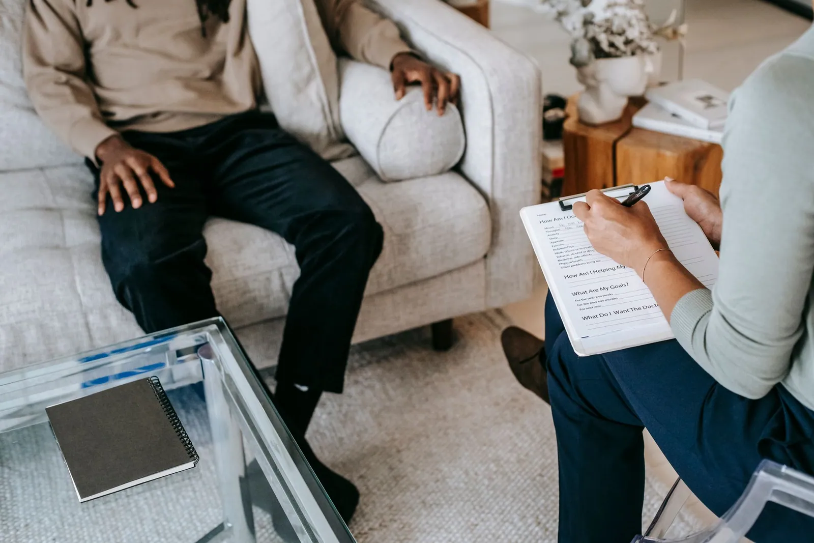 Vertrauliches Beratungsgespräch zwischen zwei Personen auf einem Sofa